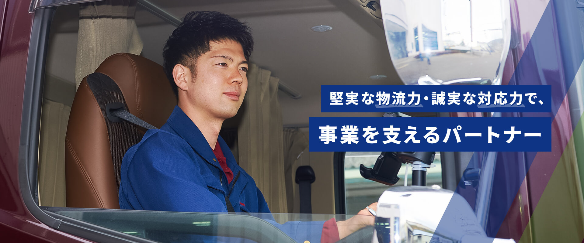 堅実な物流力・誠実な対応力で、事業を支えるパートナー トラックを運転する人物の写真